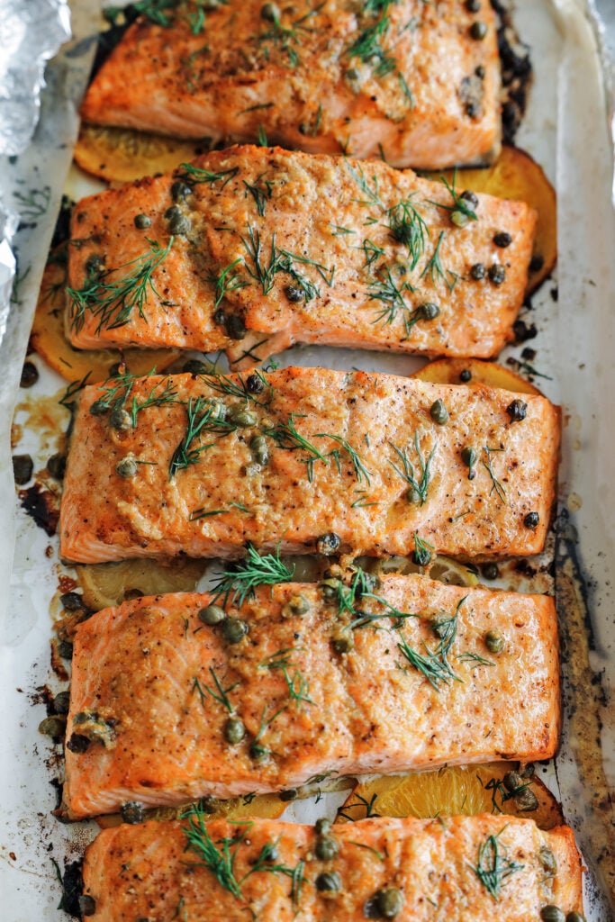 Skin-on baked salmon fillets topped with fresh dill