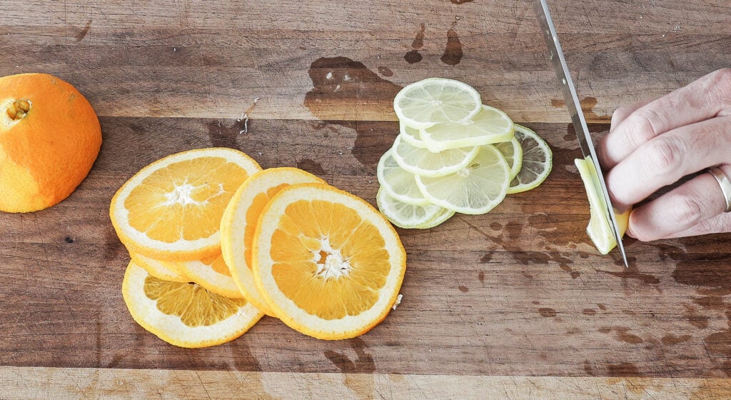 Thinly sliced lemon and orange rounds on a cutting board