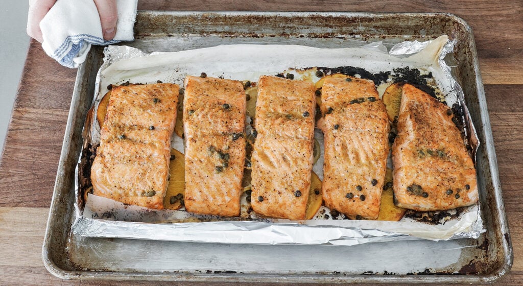 Baked salmon with a browned top on a citrus bed