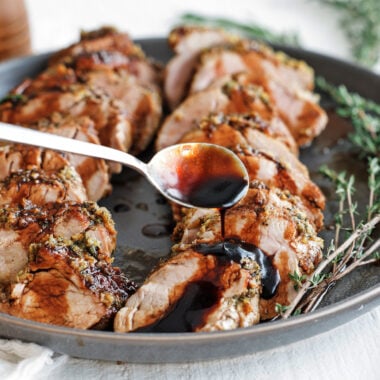 Sliced balsamic glazed pork tenderloin drizzled with sweet balsamic glaze