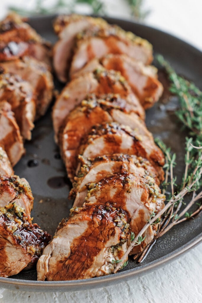 Sliced balsamic glazed pork tenderloin drizzled with sweet balsamic glaze