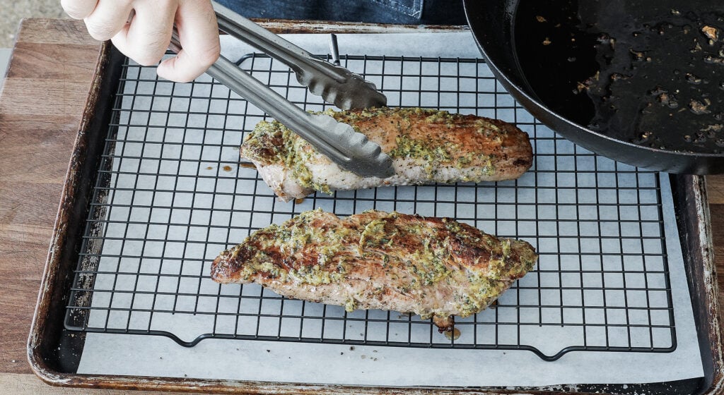 Roasted pork tenderloin resting on a wire rack