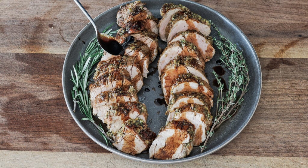 Sliced balsamic glazed pork tenderloin drizzled with sweet balsamic glaze