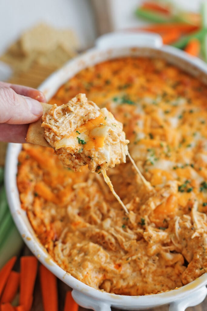 Scooping Buffalo Chicken Dip with a cracker.