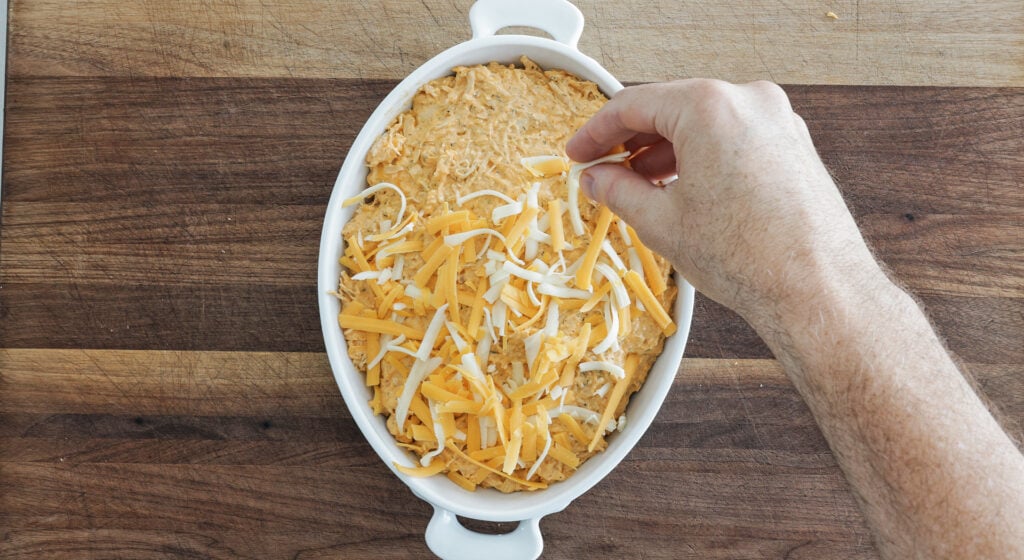 mixture spread in a baking dish and topped with a layer of shredded cheese