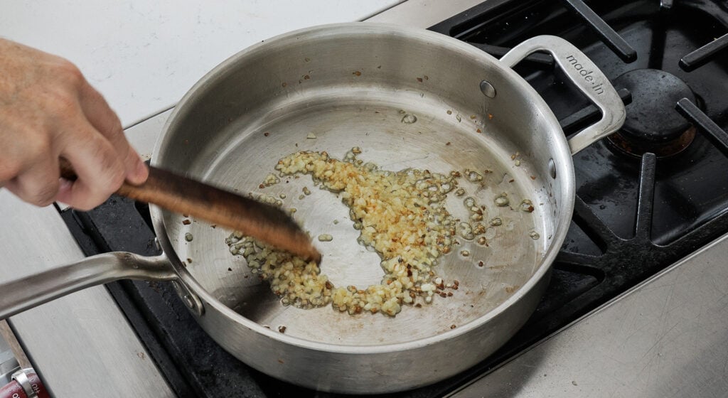 Diced yellow onion browning in olive oil in a saucepan