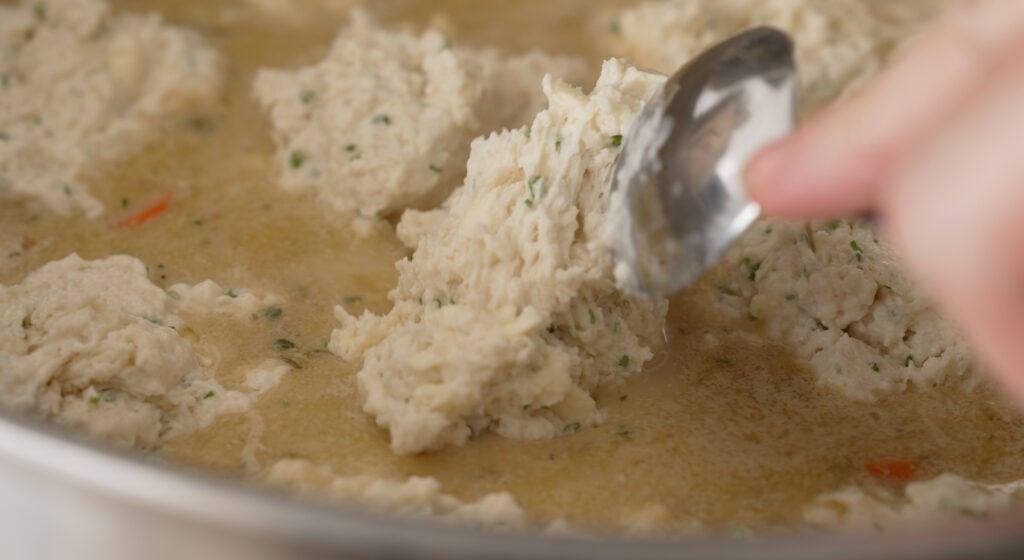 Buttermilk dumpling batter dropped in spoonfuls over the chicken stew