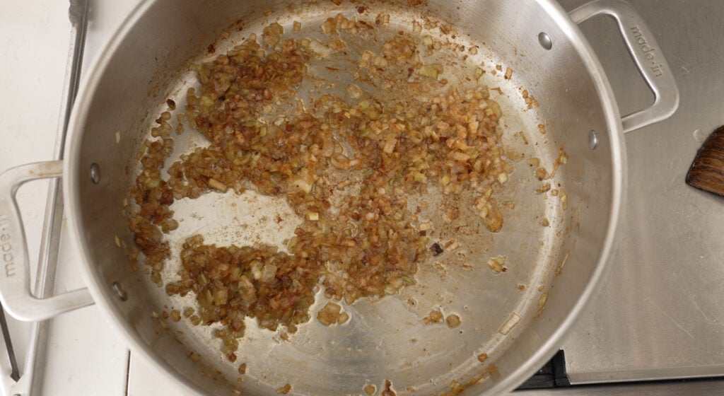 Diced onions and leeks caramelizing in the rendered chicken fat