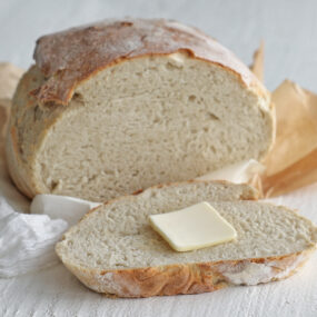 Crusty homemade dutch oven bread sliced open on a board
