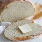 Crusty homemade dutch oven bread sliced open on a board
