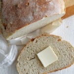 Crusty homemade dutch oven bread sliced open on a board