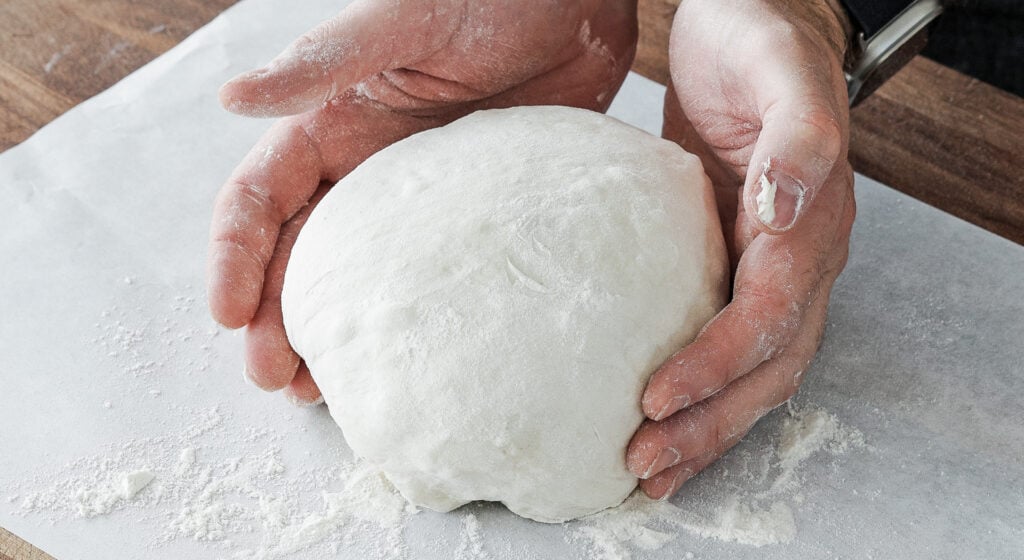Dutch oven bread dough doubled in size in the bowl after a room-temperature bulk ferment

