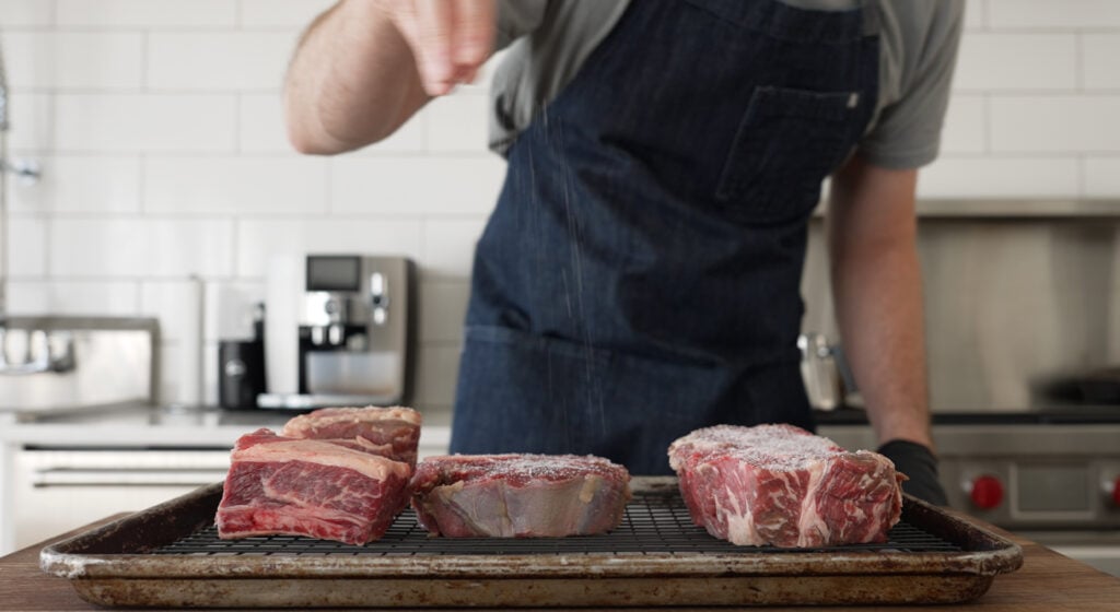 Cubed beef for peposo salted and arranged on a wire rack to dry brine in the fridge