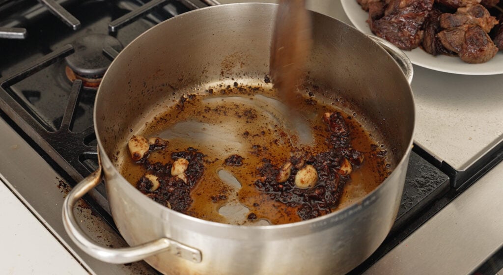 Tomato paste cooked to a rust color in the deglazed wine and pepper base 
