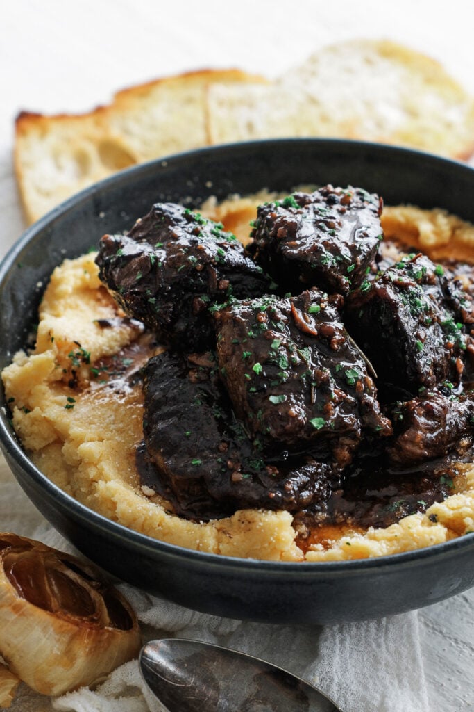 Peposo served over polenta with a parsley garnish.