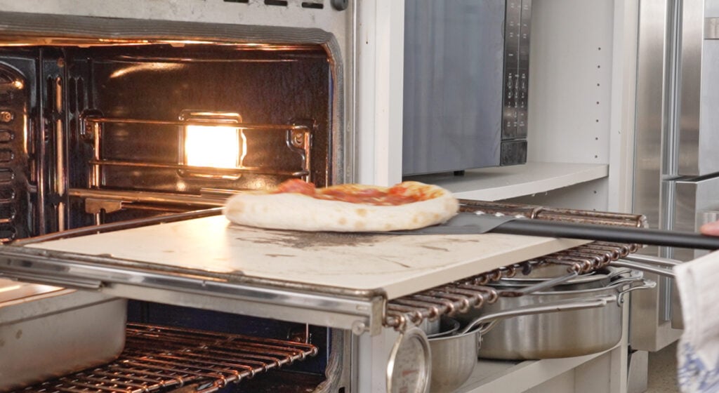 A topped sourdough pizza cooking in the oven