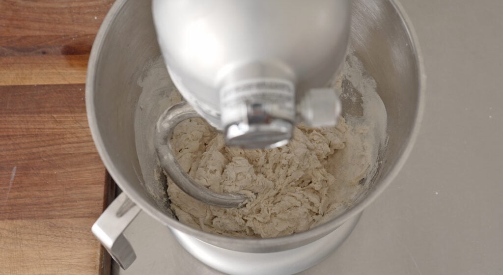 Smooth kneaded pizza dough pulling away from the sides of the mixing bowl