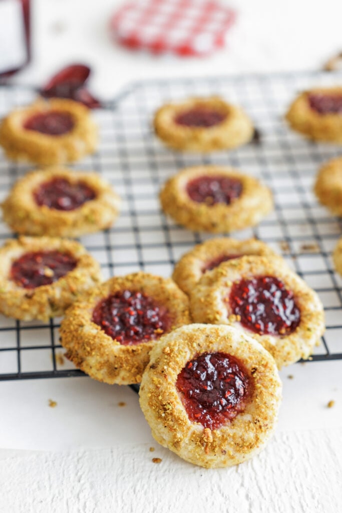 raspberry thumbprint cookies  on a wire rack
