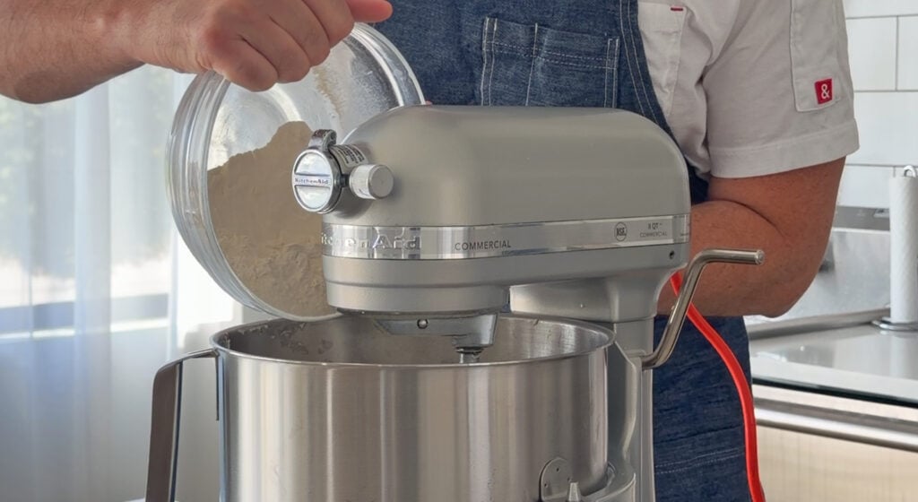 slowly adding all-purpose flour to the creamed butter and sugar in the mixer