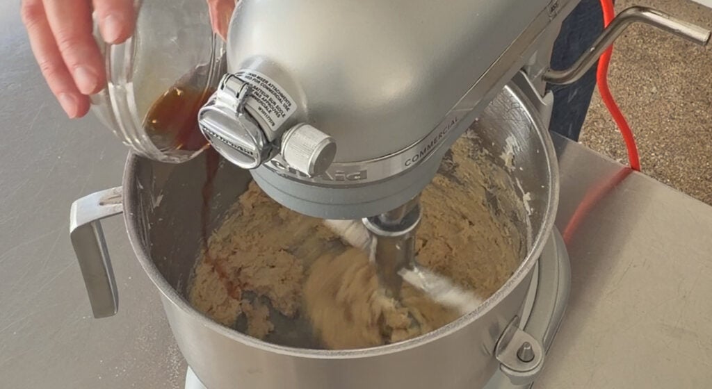 adding salt and vanilla extract to the shortbread cookie dough in the mixer
