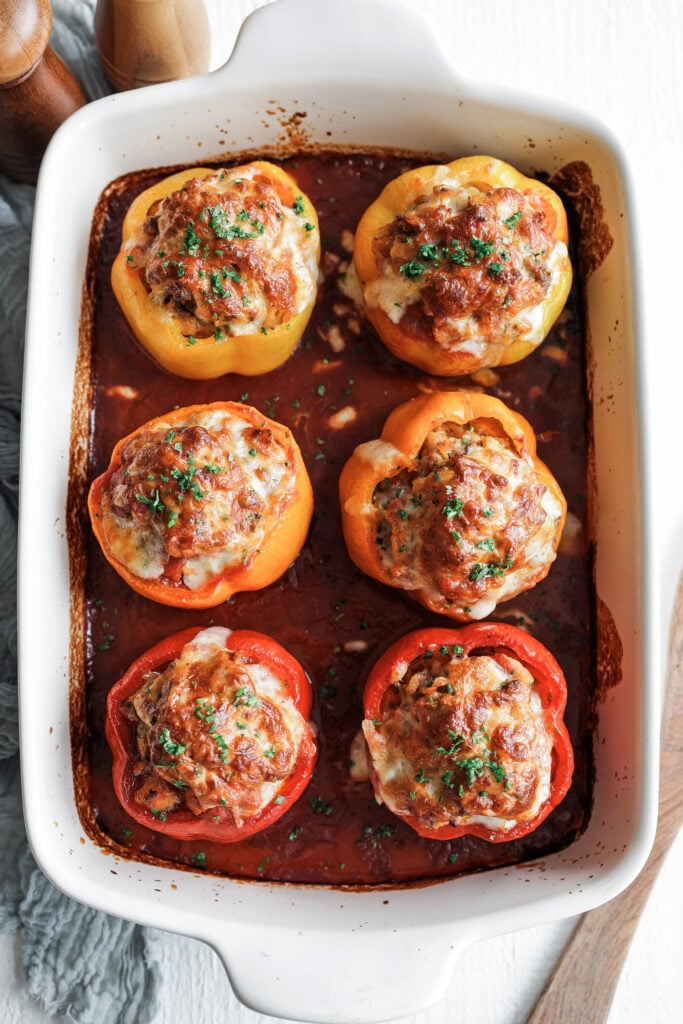 finished stuffed peppers plated with extra sauce and fresh parsley