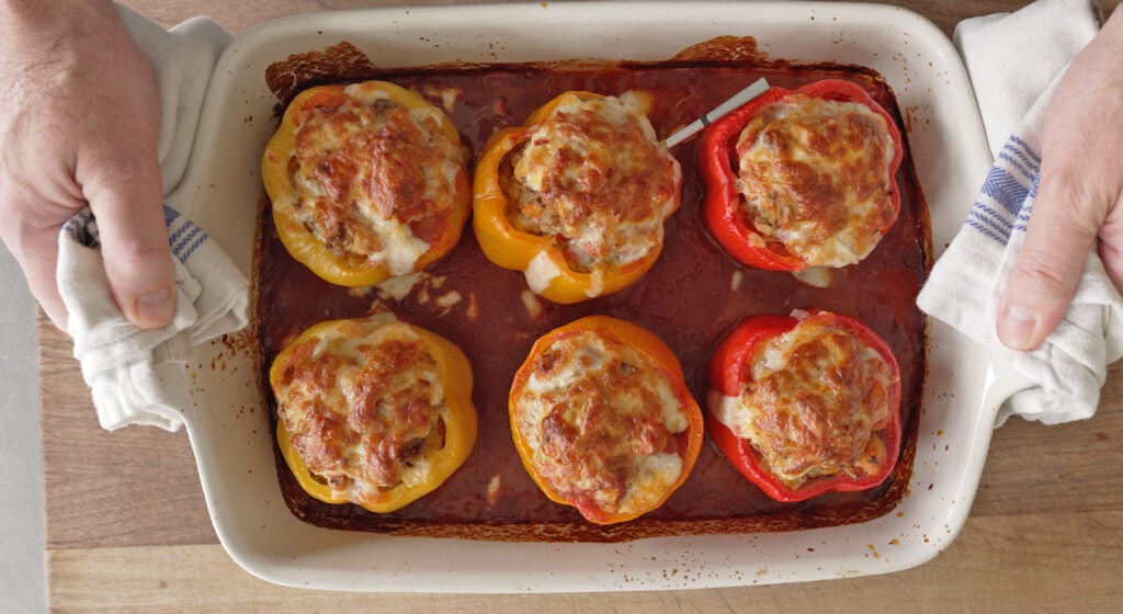 finished stuffed peppers plated with extra sauce and fresh parsley