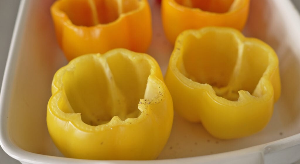 hollowed peppers rubbed with oil and roasting in the oven
